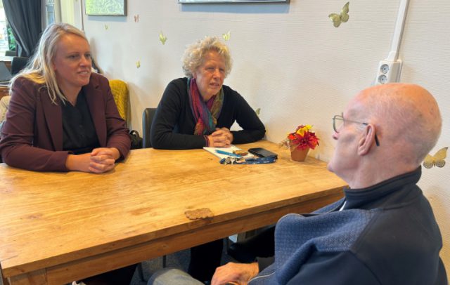 Foto: Portaal - Minko de Weerd en Leida van Duijn in gesprek met een bewoner.